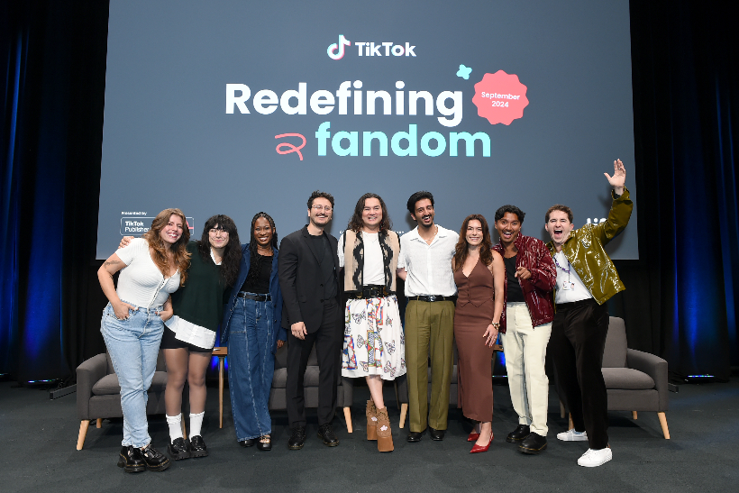 group of people on stage with TikTok backdrop